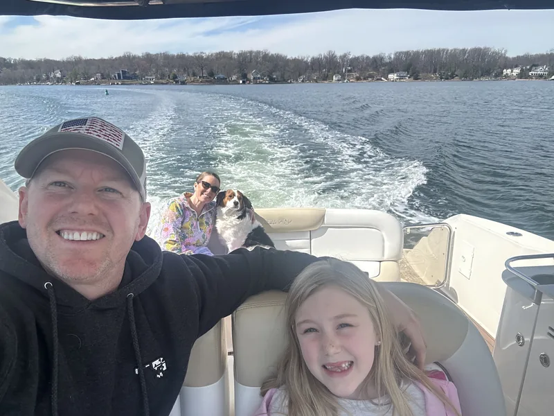 Donny Morrell with his family and their dog aboard their boat on the water